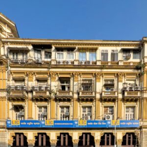 Historic colonial-style building with LIC signage, showcasing detailed architecture under a clear blue sky.